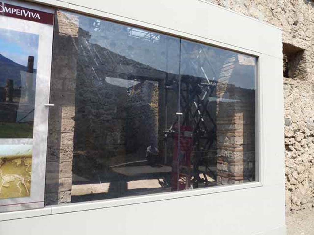 IX.12.5 Pompeii. May 2010. Entrance behind glass front. According to Spinazzola,
“On either side of entrance IX.12.4 there were two workshops with large doorways but there was no clue as to the industry carried out in these shops. The one at IX.12.3 was more modest than IX.12.5, and led into the atrium of IX.12.4, and with very narrow stairway against the left (west) wall, for the exclusive use of the atrium to the upper floor: the other one at IX.12.5 was over 5metres wide with a rear room, and completely detached from the rest of the house without any communication or doorway.”
Spinazzola, V. Pompei, alla luce degli Scavi Nuovi di Via dell’Abbondanza (Anni 1910-1923), Vol.2, p.716.