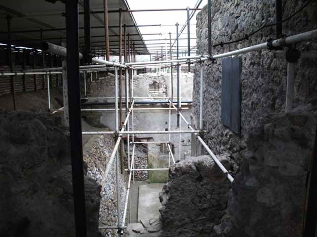 Unnamed Vicolo between IX.12 and IX.13. May 2010. Excavation behind IX.13.1. Looking east from unnamed vicolo.
According to Cerulli Irelli, “A work of excavation had been followed to isolate the humidity from the two splendid rear rooms of the said house (i.e. of IX.13.1/3 Julius Polybius), and the rustic quarters of a house has appeared to the north of this last house and presented a small kitchen with cupboard (repositorium) in a notable state of conservation, and a vast lararium picture with several elements on the rear wall of an uncovered/open room: this seemed to be evidence of plebeian art not inferior to the lararium picture found in the actual house of Julius Polybius.”
See Cerulli Irelli, G: Cronache Pompeiane, 2, (II), 1976, Notizario, attivita archeologica. (p.241).