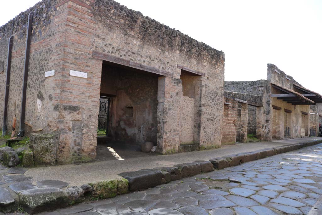 Via dell’Abbondanza, south side. December 2018. 
Looking south-west from junction with Vicolo della Nave Europa, on left, towards doorways to I.11.7 to I.11.1, on right. 
Photo courtesy of Aude Durand.
