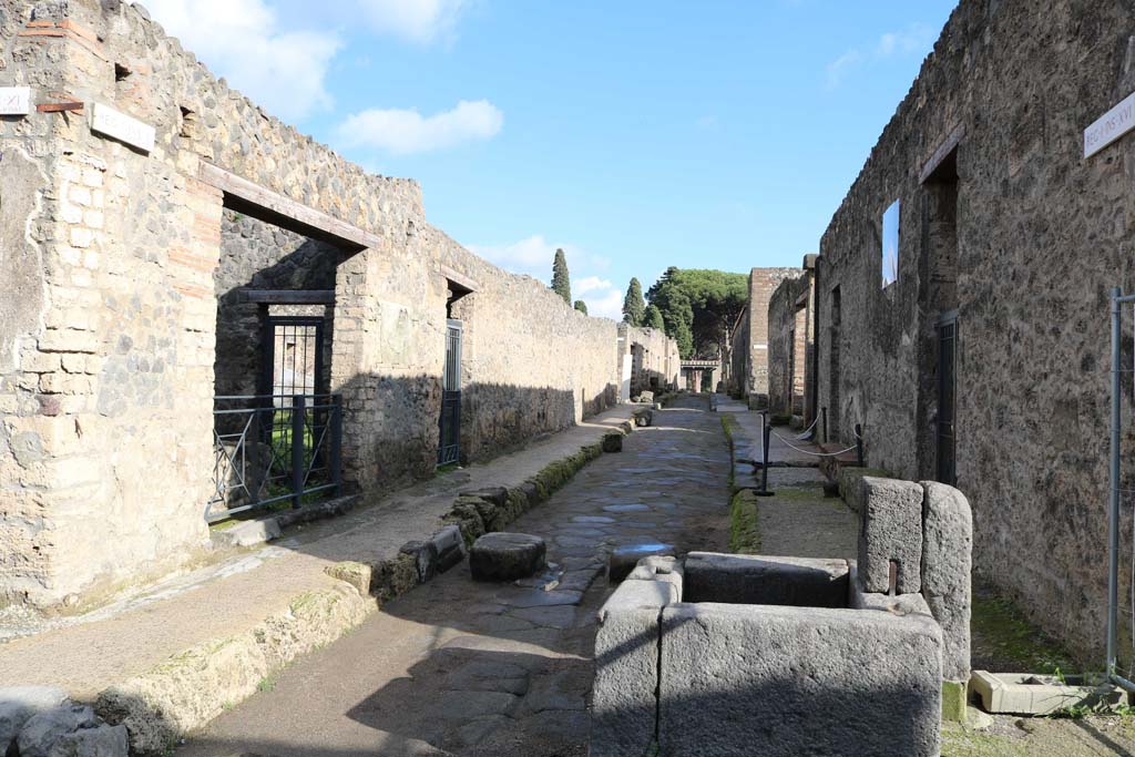 Via di Castricio, Pompeii. December 2018. 
Looking east along I.11, on left, and I.16, on right, from near fountain outside I.16.4. Photo courtesy of Aude Durand.
