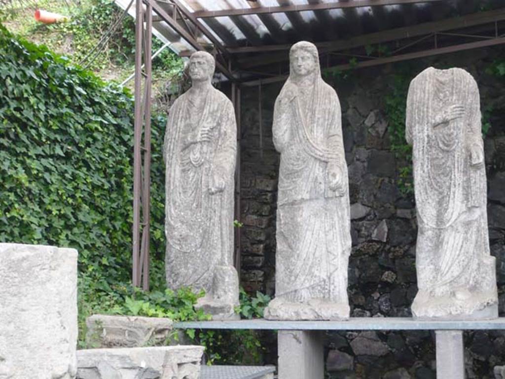 Pompeii Porta Nocera. May 2011. South side of the Via delle Tombe between tombs OS and ES.
Three statues from tomb 34aEN, now in display area for items found in and near the tombs. 
Photo courtesy of Buzz Ferebee.


