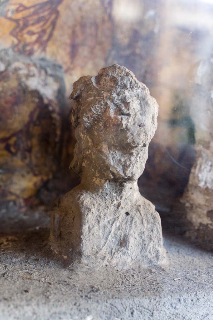 I.10.4 Pompeii. April 2022.
Alcove 25, detail of plaster cast, on the left, on the lararium or domestic shrine. (Image 1).
Photo courtesy of Johannes Eber.