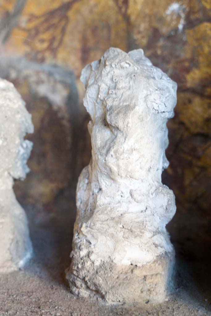 I.10.4 Pompeii. April 2022.
Alcove 25, detail of plaster cast, seen on the left of centre, on the lararium or domestic shrine. (Image 2).
Photo courtesy of Johannes Eber.