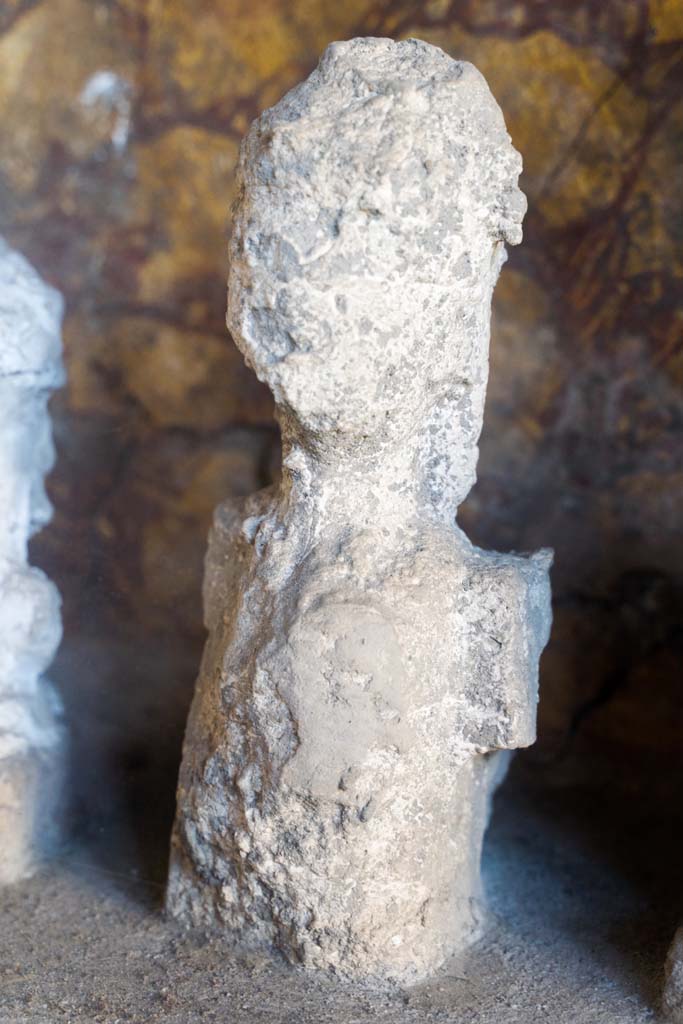 I.10.4 Pompeii. April 2022.
Alcove 25, detail of plaster cast, seen on the right of centre, on the lararium or domestic shrine. (Image 2).
Photo courtesy of Johannes Eber.