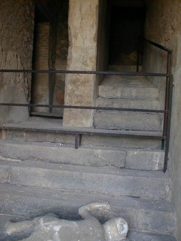 VII.16.17-22 Pompeii. May 2006. Looking up towards the stairs where a group of fugitives were found, and where one still lies at the foot of staircase.
