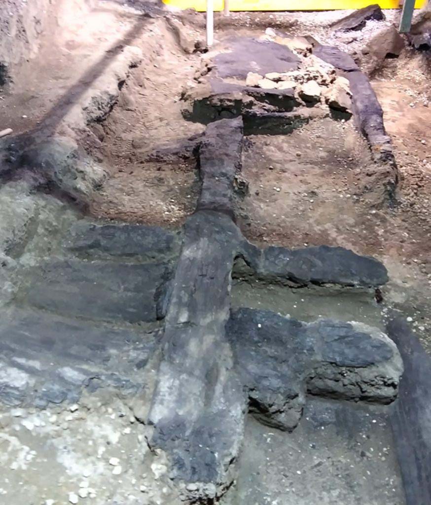 Cività Giuliana. February 2021. 
An excavation was subsequently carried out which reached a depth of 6 metres relative to the road level, with stabilisation both of the excavation fronts and the robust masonry structures - which were preserved up to a level of 4 metres - that emerged over the course of the investigations.

From the very beginning, the excavation of the room where the chariot was found revealed its exceptional nature: the area in question is in fact a double-level portico which opens onto an uncovered courtyard, and which features the carbonised wooden ceiling with its network of beams, preserved in its entirety.

Archaeobotanical analyses have been carried out on the wood, which have shown that the ceiling was constructed of deciduous oak wood (Quercus sp. – cf. robur - English oak), a timber which was frequently used in the Roman age for structural elements. The carbonised wooden structure of the door on the southern side of the room, which connected the portico to the stable where the three equids were recently discovered, was also preserved, and upon analysis was identified as beechwood.

The wooden ceiling was carefully consolidated, cleaned, and removed from the excavation area in order to permit the investigations to continue.

Cività Giuliana. Febbraio 2021.  
Si è quindi proceduto ad uno scavo che ha raggiunto i 6 metri di profondità rispetto al piano stradale, mettendo in sicurezza sia i fronti di scavo che le possenti strutture murarie – conservate fino a 4 m. - che emergevano nel corso delle indagini

Lo scavo dell’ambiente dove si è rinvenuto il carro ha mostrato fin dall’inizio la sua eccezionalità: si tratta infatti di un portico a due piani, aperto su una corte scoperta, che conservava in tutta la sua interezza il solaio ligneo carbonizzato con il suo ordito di travi.

Si sono condotte analisi archeobotaniche del legno che hanno mostrato come il solaio fosse stato realizzato in legno di quercia decidua (Quercus sp. – cfr. robur - farnia), un legno frequentemente utilizzato in età romana per realizzare elementi strutturali. Anche la porta sul lato sud della stanza, che metteva in comunicazione il portico con la stalla dove negli scorsi anni si sono rinvenuti 3 equidi, conservava la sua struttura in legno carbonizzato che è stato analizzato e identificato come faggio.

Il solaio ligneo è stato accuratamente consolidato, pulito e rimosso dall’area di scavo per permettere il proseguimento delle indagini.

Photograph © Parco Archeologico di Pompei.
