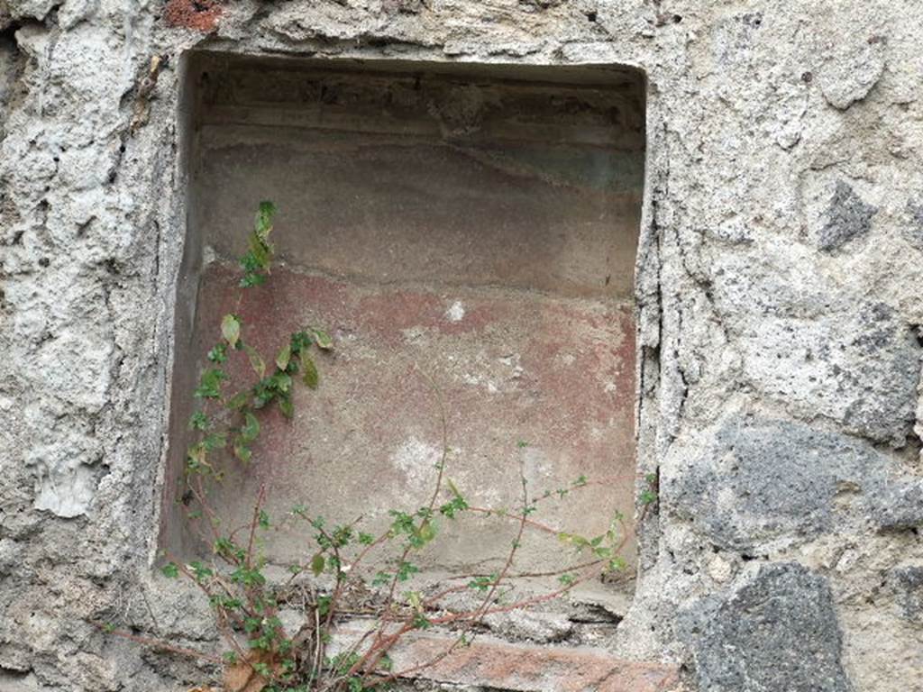 I.2.10 Pompeii. December 2006. Niche in North wall of garden. 
According to Boyce, this had a ledge formed by a tile projecting on the level of its floor: the inside walls were red, the stucco ornaments red, white and blue. 
See Boyce G. K., 1937. Corpus of the Lararia of Pompeii. Rome: MAAR 14. (p.22, Pl.1,1) 
See Jashemski, W. F., 1993. The Gardens of Pompeii, Volume II: Appendices. New York: Caratzas. (p.22)
See Pappalardo, U., 2001. La Descrizione di Pompei per Giuseppe Fiorelli (1875). Napoli: Massa Editore. (p.35)
See Giacobello, F., 2008. Larari Pompeiani: Iconografia e culto dei Lari in ambito domestico.  Milano: LED Edizioni. (p. 252)
