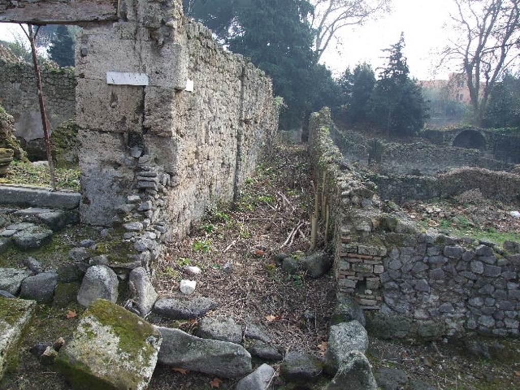 I.5.1 Pompeii. December 2006. Unnamed vicolo looking south, between 1.5 and I.1. 

Warscher quoting Mau in Bull. Inst.1875, p.25, described Vicolo del Conciapelle as Via tertia, - “L’insula 5 della Regione I e quasi tutta occupata dalla conceria. Fuori di essa non vi è che il compreso rozzo sul lato E ed una bottega con tre camere sul cantone NO”

Quoting Sogliano in Giorn, Sc. III, no.21, 1874, p.8, she wrote –
“Chiameremo 5 per l’ordine cronologico dei cavamenti quest’isola della I Regione, la quale per essere parallela e vicina alla I doverebbe piuttosto dirsi 2.  Considerando la parte finora scoverta, osserviamo a prima vista che la sua costruzione offre in taluni punti grandi lastre del tufo di Sarno, in altri quello di Nocera, e per lo più l’opus incertum. I tre vicoli, che rasentano ad oriente, settentrione ed occidente, non sono lastricati; il settentrionale è accessibile solo per i due altri margines, ricongiunti nel mezzo di esso da un piccolo ponte in fabbrica.  Quest’isola, per la sua situazione presso la porta Stabiana e per la sua località, sembra sia stata abitata in gran parte da persone viventi col commercio e coll’industria”.
See Warscher T., 1936. Codex Topographicus Pompeianus: Regio I.1, I.5. Rome: DAIR, whose copyright it remains. 
