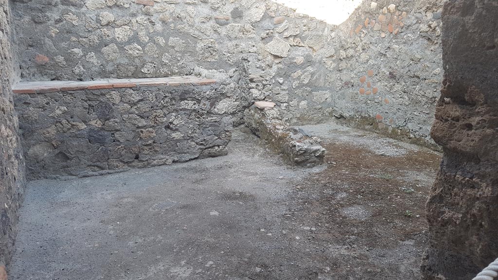 .6.4 Pompeii. August 2023. 
Room 8, looking through doorway towards east wall with hearth, on left, and latrine, on right. Photo courtesy of Maribel Velasco.

