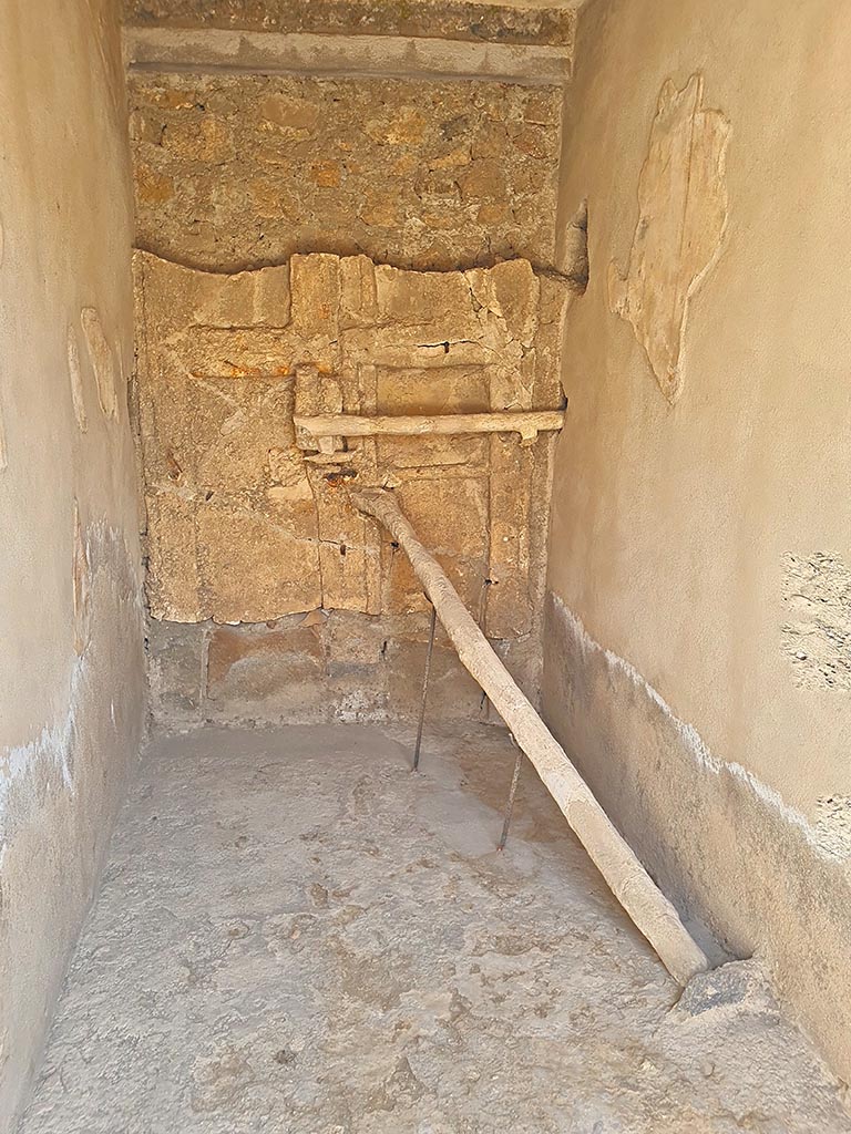 I.7.10/11 Pompeii. September 2024. Detail of the blocked entrance at I.7.10.  
Detail of cement cast of door with two shutters reinforced with a horizontal crossbar and a pole positioned into a hollow in the floor.
Photo courtesy of Giuseppe Ciaramella.
