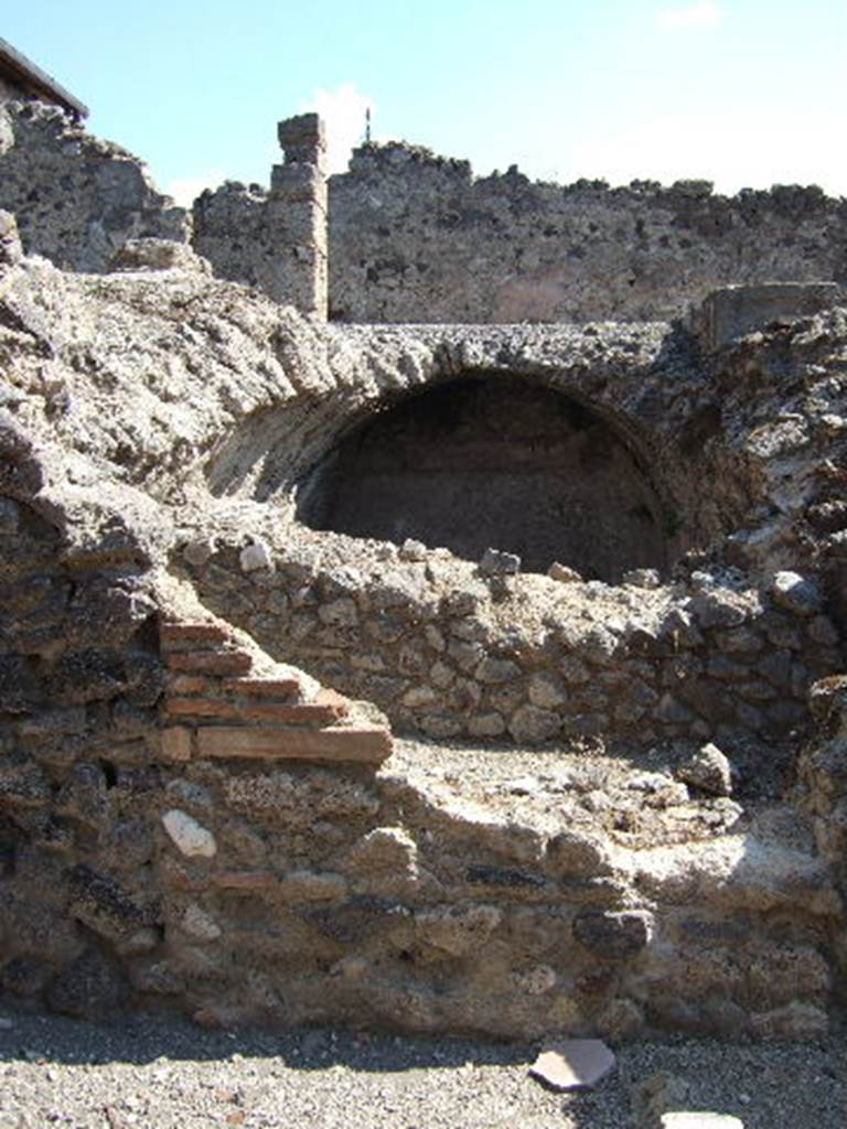 I.8.19 Pompeii. September 2005. Cistern at lower level, with peristyle of I.8.2 above. According to Jashemski, part of the floor on the north, east and west portico of the peristyle of I.8.2, was destroyed by bombing in 1943.  A gutter at the edge of the garden collected rain water which was stored in the large cistern under the peristyle. The water appeared to have been used in the adjacent dye-shop (I.8.19) at the rear. See Jashemski, W. F., 1993. The Gardens of Pompeii, Volume II: Appendices. New York: Caratzas. (p.42)
