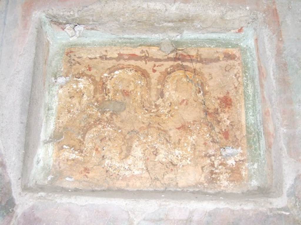 I.10.7 Pompeii. March 2009. Room 12, east wall of triclinium.  
Lararium niche set in third style decoration. Two crested and bearded brown serpents with yellow underbellies are creeping to the left between red flowers and green plants. On the right is an altar.
See Frhlich, T., 1991. Lararien und Fassadenbilder in den Vesuvstdten. Mainz: von Zabern. (L15: p.256)
According to Boyce, this shallow rectangular niche was set into (but not in the centre of) a fine panel of wall decoration, which it disfigured.
(According to the note by Boyce, Elia had said in Not.Scavi, that these panels were painted shortly after the earthquake of 63 AD).
Both serpents coil from the left towards an altar, as in the other lararium described in the kitchen. In the background were green plants with red flowers. Not. Scavi, 1934, 287.
See Boyce G. K., 1937. Corpus of the Lararia of Pompeii. Rome: MAAR 14. (p.29, no.57)
