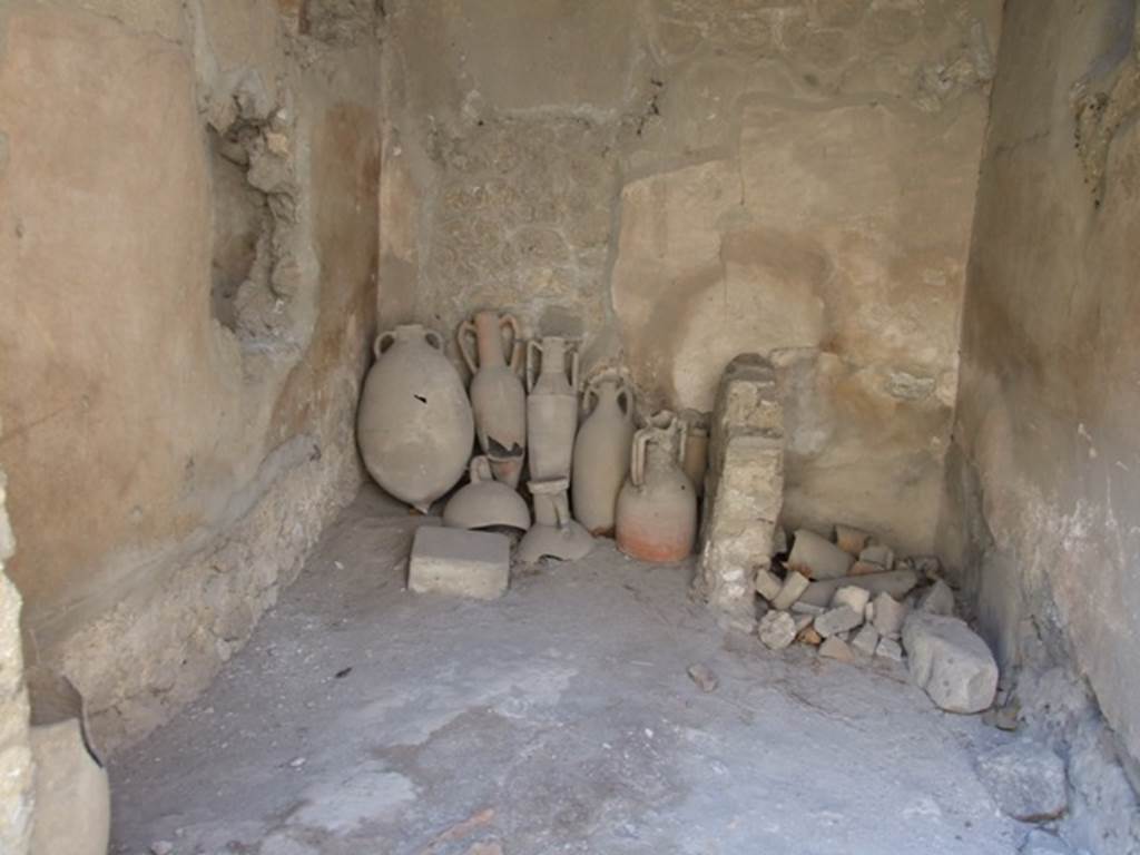 I.10.7 Pompeii. March 2009. Room 1, west wall, with latrine in north-west corner.
According to NdS 
The upper floor: 
Above the west side of the atrium and above the oecus (room 8) would have been a small area of five or six rooms, all more or less decorated in a scheme of the 4th Style.  The upper parts of the walls were preserved only partially for the first 4 rooms nearer to the roadway; all the rest were destroyed and reconstructable only by some traces. The access to this series of rooms would have been by the wooden stairs of room 1, which passed over the top of the latrine but there was also a masonry staircase which led to the walkway above the kitchen,
See Notizie degli Scavi, 1934, (p.292)
