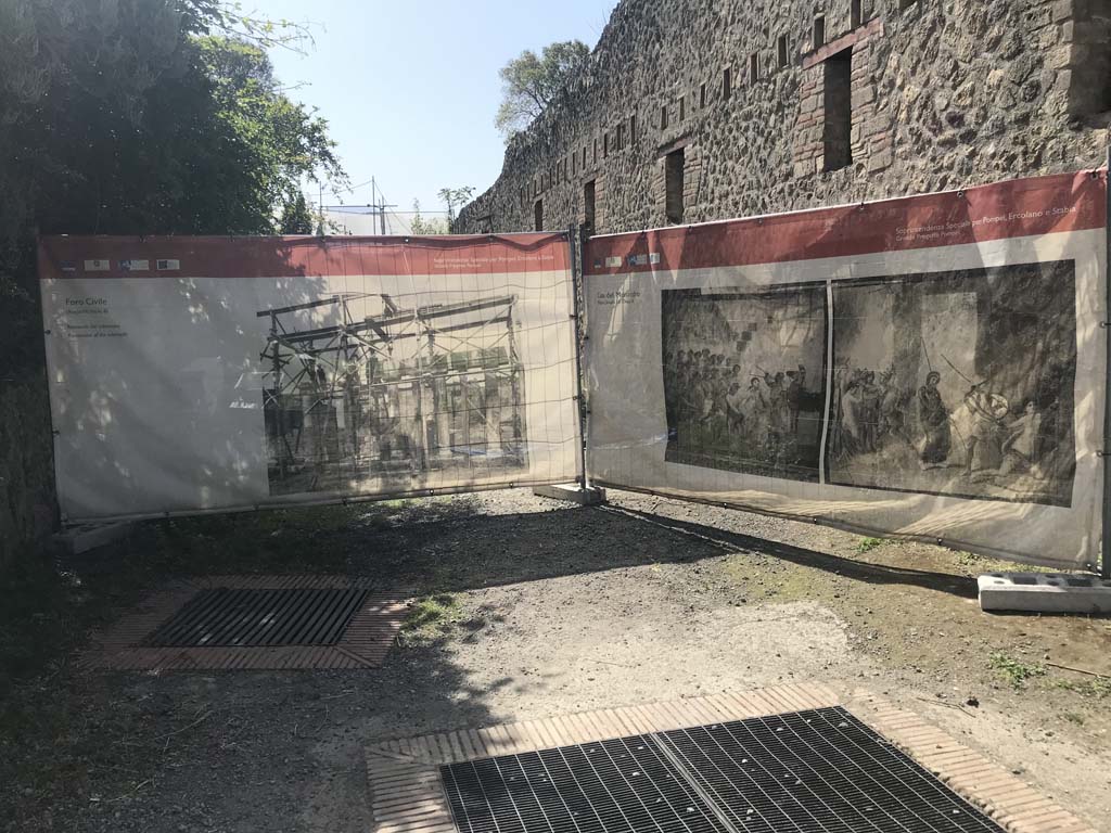 Vicolo di Paquius Proculus, April 2019. 
Looking south along east side faade of House of Menander, the entrance of I.10.15 would be behind the display screen.
I.19 is on the left. 
