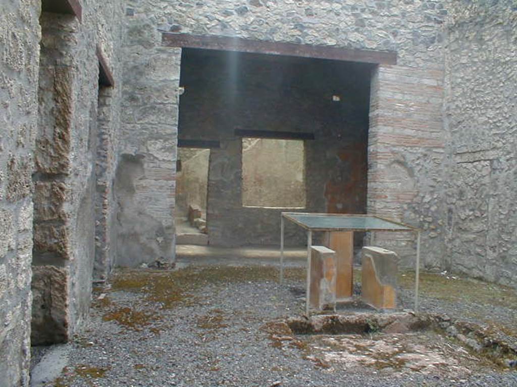 I.11.6 Pompeii. September 2004. Looking south across atrium and impluvium, with legs of table.