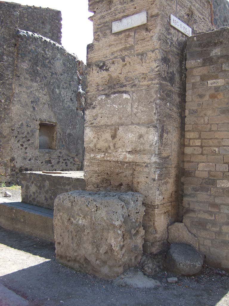 Street altar outside II.2.1 on Via dell’Abbondanza. September 2005. 
According to Fröhlich (from the only source - Spinazzola), in front of the wall stood a white plastered masonry altar.
Above this, the remains of an older painting were visible through a newer lime layer.
This showed five figures, probably the vicomagistri and a tibicen, and a tablet with illegible names.
See Fröhlich, T., 1991. Lararien und Fassadenbilder in den Vesuvstädten. Mainz: von Zabern. (F17, p. 312).
