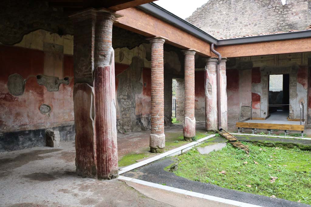 II.4.6 Pompeii. December 2006. Looking north along east wall towards benches and entrance doorway.
