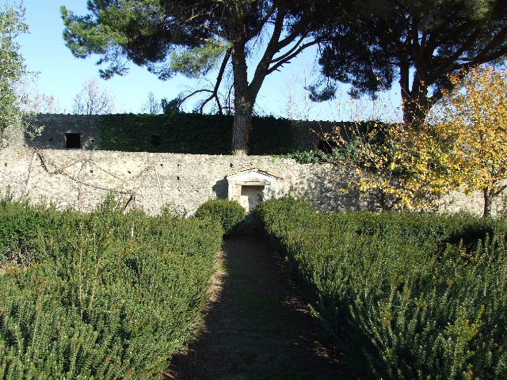 II.8.6 House of the Garden of Hercules.    Lararium on east wall of garden.