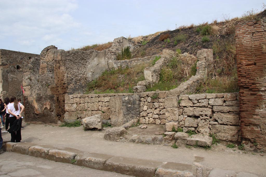 III.6.4 Pompeii, in centre. May 2024. 
In the centre, is the entrance doorway/corridor into the unexcavated Casa di M. Satrius at III.6.4, with upper rear west walls showing. 
The shop at III.6.3 is on the left of the entrance doorway to corridor. Photo courtesy of Klaus Heese
