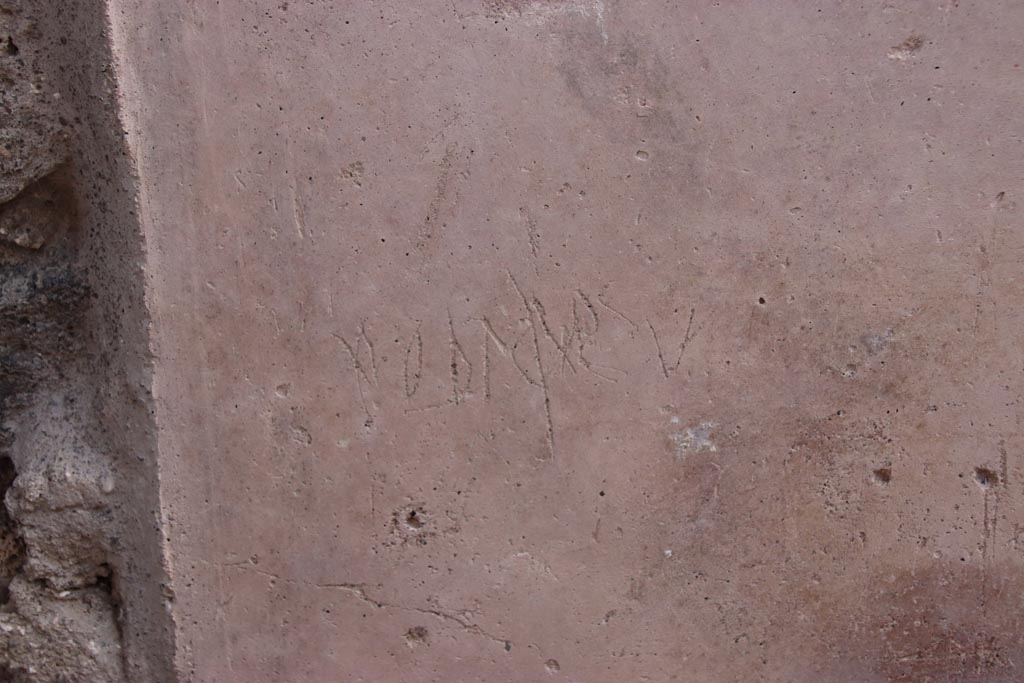 V.3 Pompeii. Casa del Giardino. October 2022. 
Graffiti on south (right) wall of entrance doorway/corridor/fauces, on the same wall below the graffiti in the photo above.
Photo courtesy of Klaus Heese. 
