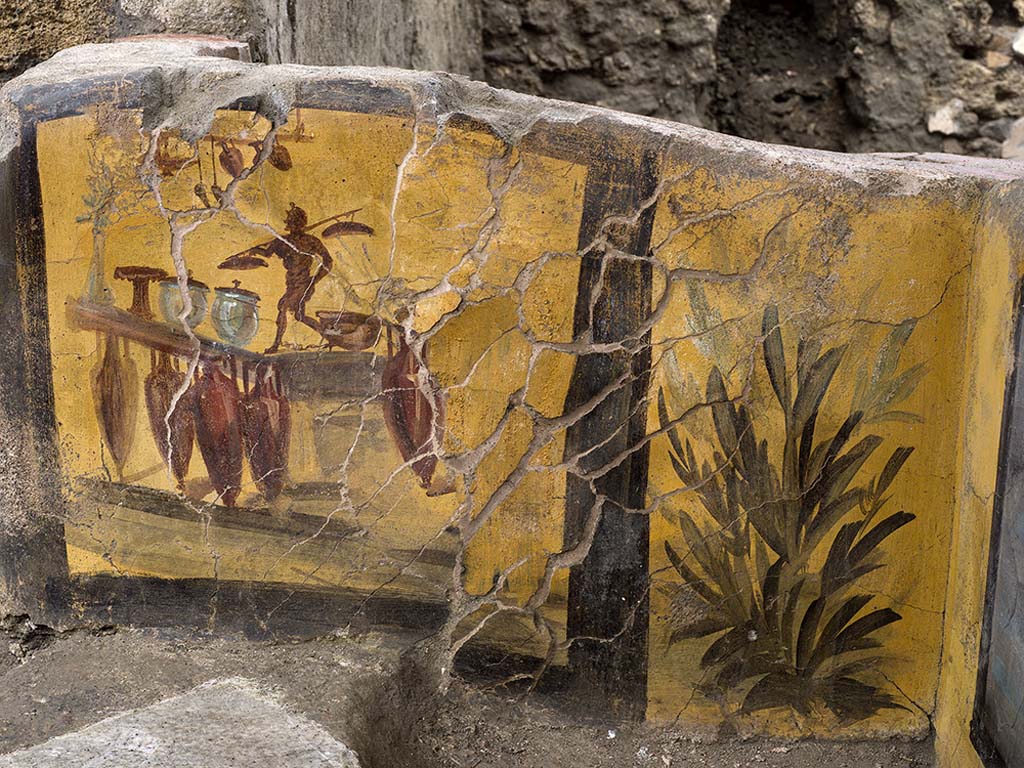 V.3 Pompeii, Thermopolium with painting of nereid. December 2020.
The shorter side features an illustration which is probably of the shop itself, like a kind of trademark. 
It was not by chance that the discovery during the excavation of amphorae, located in front of the counter, reflected the painted image.

V.3 Pompei, Termopolio con dipinto di nereide e anfore. Dicembre 2020.
Sul lato più corto e l'illustrazione, probabilmente della bottega stessa alla stregua di un'insegna commerciale. 
Il ritrovamento, al momento dello scavo, di anfore poste davanti al bancone rifletteva non a caso l'immagine dipinta.

Photo by Luigi Spina courtesy of Parco Archeologico di Pompei.
