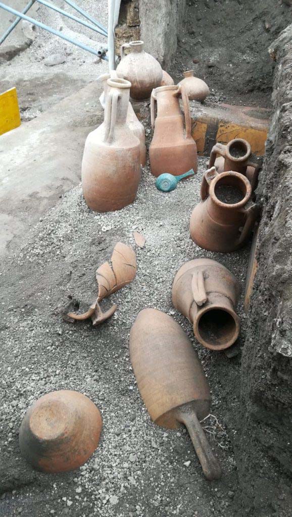 V.3 Pompeii. March 2019. 
Thermopolium at the crossroads between Vicolo delle Nozze d’Argento and Vicolo dei Balconi. 
The discovery of amphorae located in front of the counter, a bronze measure/pan and jars on top of the counter.
In the Thermopolium, various pantry and transport materials were discovered, including: nine amphorae, a bronze patera, two flasks and a common ceramic table olla. 

V.3 Pompei. Marzo 2019. Termopolio all'incrocio tra il Vicolo delle Nozze d'Argento e il Vicolo dei Balconi.
La scoperta di anfore situate davanti al bancone, una misura / padella in bronzo e vasetti in cima al bancone.
Nel termopolio è stato rinvenuto diverso materiale da dispensa e da trasporto: nove anfore, una patera di bronzo, due fiasche, un'olla di ceramica comune da mensa. 

Photograph © Parco Archeologico di Pompei.
