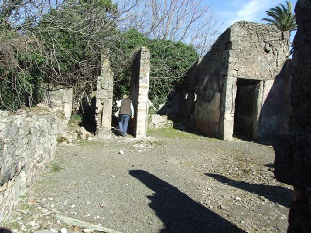 V.4.c Pompeii.  March 2009. Looking east across north side of atrium, room B. On the right of the photo, on the south side of the doorway of room H, a painting of Mercury was found in a large red panel. He was turned slightly to the right, standing, leaning on his right leg and hip, naked except for a long pink cloak, and helmet. His boots were almost faded but without doubt were winged. In his left he held the staff against his corresponding shoulder, and with his right hand he held the purse. On the ground at his feet, was the omphalos with the serpent around it. See Notizie degli Scavi, 1905, p.131.
