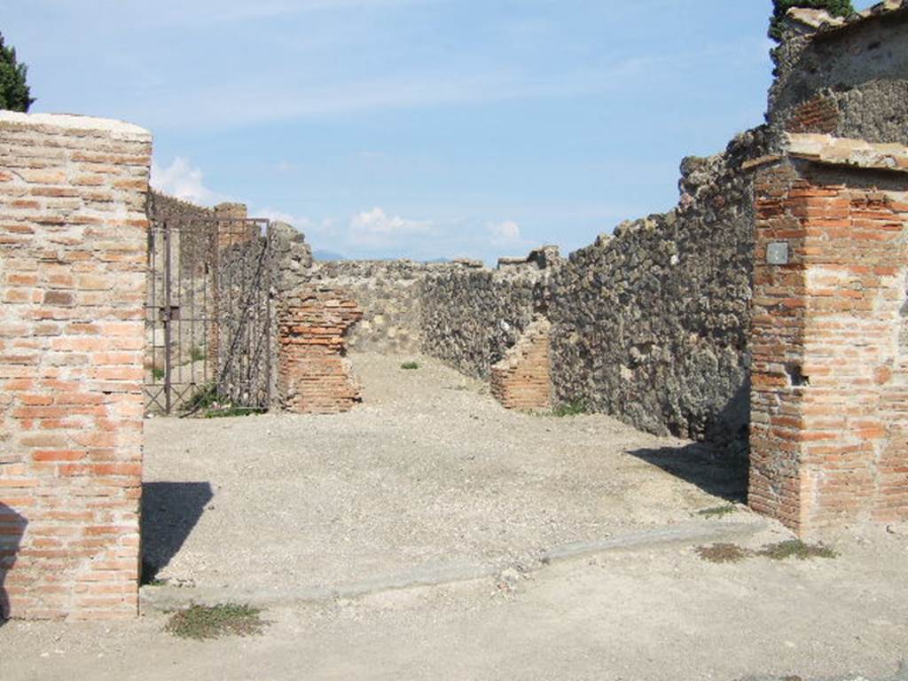 VI.1.4 Pompeii. September 2005. Entrance. According to Fiorelli, found on the wall at the side of the entrance was a graffito, now disappeared
C. CVSPIVM  PANSAM
AED  MVLIONES  VNIVERSI
AGATHO  VAIO
He described the inn as having two small rooms, a triclinium, three dormitories, two areas for the carts without doors but protected by a roof, and to the right, the stable. See Pappalardo, U., 2001. La Descrizione di Pompei per Giuseppe Fiorelli (1875). Napoli: Massa Editore. (p.47)
According to Pagano and Prisciandaro, found here in August 1770 were two graffiti, the first painted in black letters read 
C(aium) Cuspium Pansam
aed(ilem) muliones universi
Agatho vaio    [CIL IV 97]
and on the same wall, but higher up painted in red was 
Postu[mium 3]
Iulius Polybius college
facit                   [CIL IV 98]
See Pagano, M. and Prisciandaro, R., 2006. Studio sulle provenienze degli oggetti rinvenuti negli scavi borbonici del regno di Napoli.  Naples : Nicola Longobardi. (p. 67)  PAH I, 1, 242.
According to Della Corte, found here were two skeletons of horses with the remains of their harnesses and iron wheels. In the courtyard, as well as two fountains or drinking troughs, were the remains of three carts.
See Della Corte, M., 1965.  Case ed Abitanti di Pompei. Napoli: Fausto Fiorentino. (p.31)
