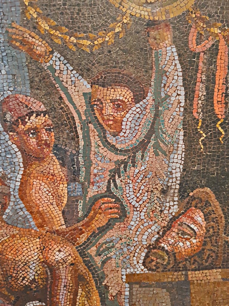 VI.8.3/5 Pompeii. September 2024. 
Detail from mosaic of a youth helping another actor put on his costume. Photo courtesy of Giuseppe Ciaramella.
