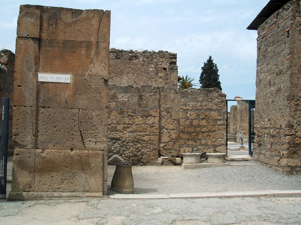 VI.12.1 Pompeii. May 2005. Shop entrance doorway, looking north.  
According to Fiorelli, found painted on the first corner pilaster, on the left, were the remains of an Eituns, or Oscan inscription.
Only a few letters were still visible.
See Pappalardo, U., 2001. La Descrizione di Pompei per Giuseppe Fiorelli (1875). Napoli: Massa Editore. (p.71)
See Antonini, R., in Quaderni Di Studi Pompeiana, 1/2007, Assoc. Int. Amici di Pompei, p. 57-73.
