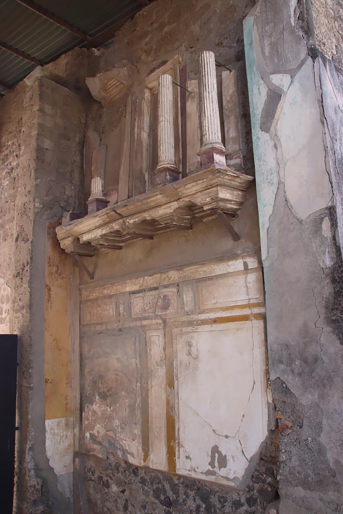 VI.12.2 Pompeii. October 2023.
Entrance fauces/corridor, looking towards west wall with shelf, on which is placed a façade with small columns.
Photo courtesy of Klaus Heese.
