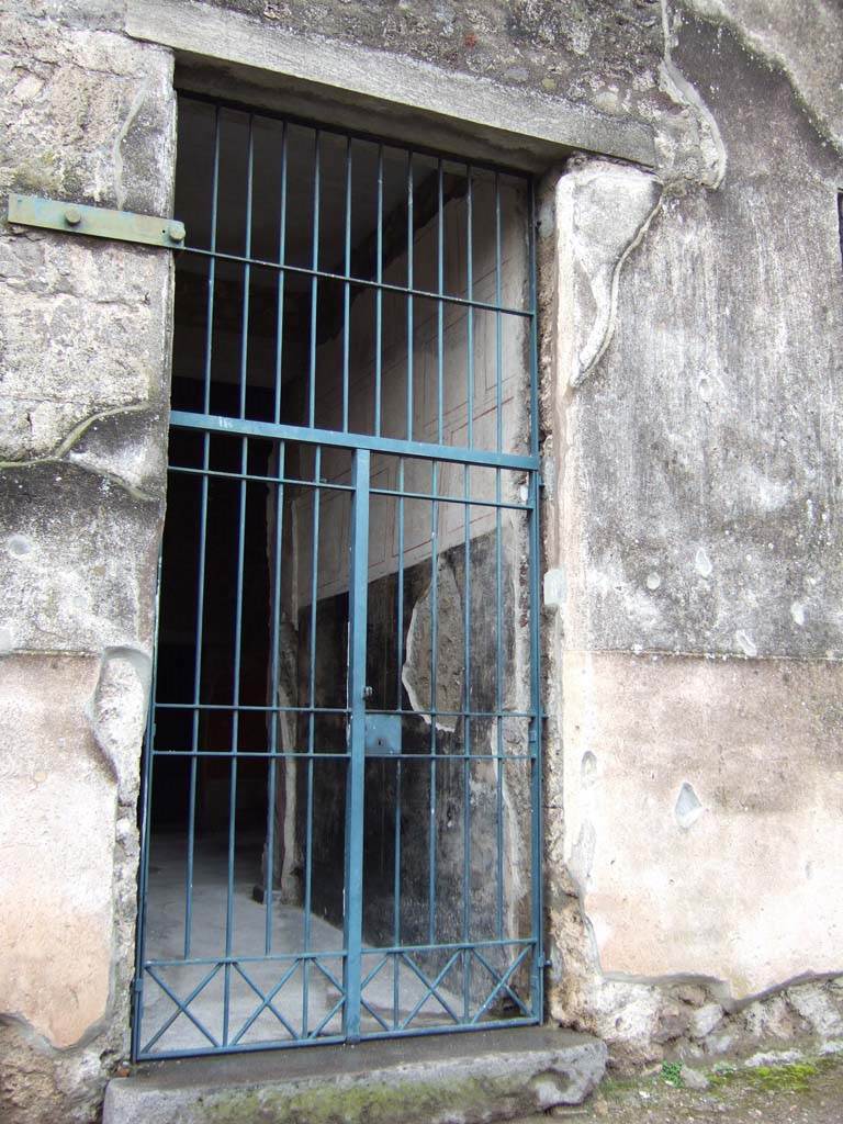 VI.15.8 Pompeii. December 2005. Entrance with painted wall on north side of entrance corridor.
According to NdS –
the walls of the fauces, or entrance corridor, were decorated on a white background, which was then partitioned with black and red lines.
The high dado, or ‘zoccolo’ was painted black.

