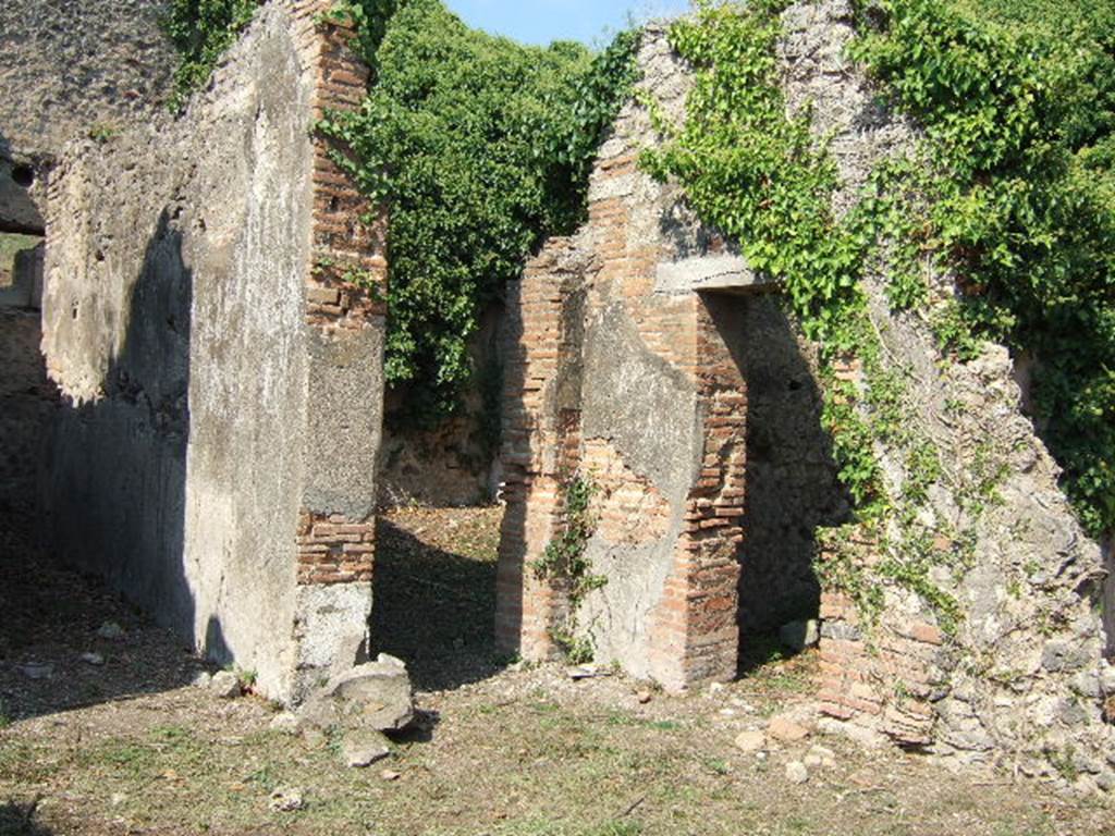 VI.15.20 Pompeii. September 2005. Looking north-east from atrium towards doorways to corridor to kitchen, left, and oecus, centre. According to Hobson, Reg. VI had two upper storey latrines that still had visible signs of the latrine above the ground floor level, these were in VI.15.20 and VI.15.22.  See Hobson, B., 2009. Latrinae et foricae: Toilets in the Roman World. London; Duckworth. (p.75)
According to Eschebach, the corridor on the north side of the atrium led to the kitchen and latrine which had a downpipe from the upper floor. See Eschebach, L., 1993. Gebudeverzeichnis und Stadtplan der antiken Stadt Pompeji. Kln: Bhlau. (p.223)

According to NdS, only the lower part of the walls of the oecus were faced with white plaster, partitioned by black lines. In the south wall was a small niche. See Notizie degli Scavi di Antichit, June 1897, (p.275)

In the room to the north of the tablinum, the doorway on the right of this photo, a pile of lime prepared for work was found, together with some tiles. (p.274)

