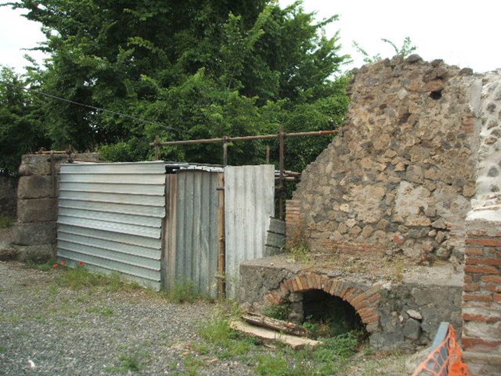 VI.17.1 Pompeii. May 2005. Looking north-west from entrance, towards rooms on north side, and remains of hearth in kitchen.