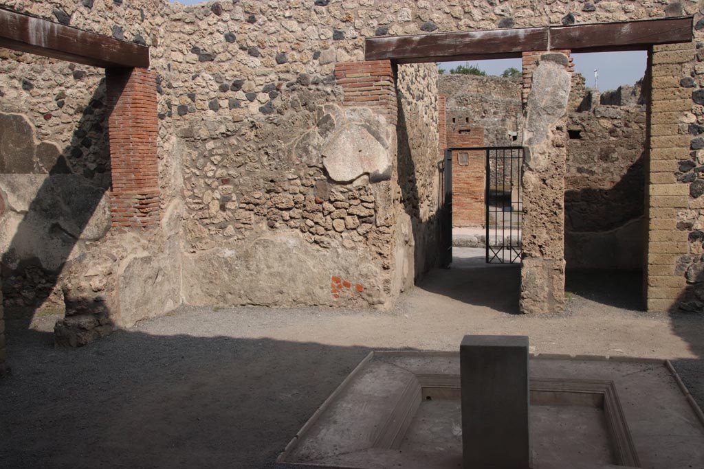 VII.1.25 Pompeii. October 2023. 
Looking east across impluvium in atrium 24 to fauces 23 and entrance VII.1.25. Photo courtesy of Klaus Heese.
