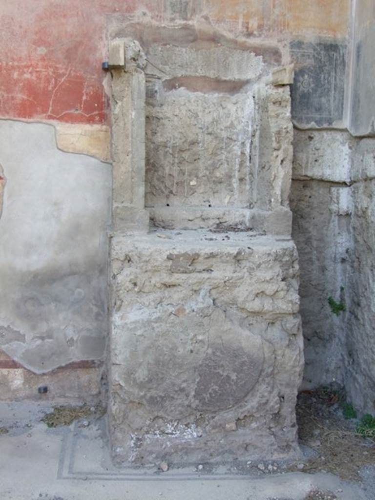 VII.4.31 Pompeii. March 2009. Room 6, lararium against west wall. 
On the front of the base there is an impression of a round plaque in the plaster.  This must have once decorated it.

