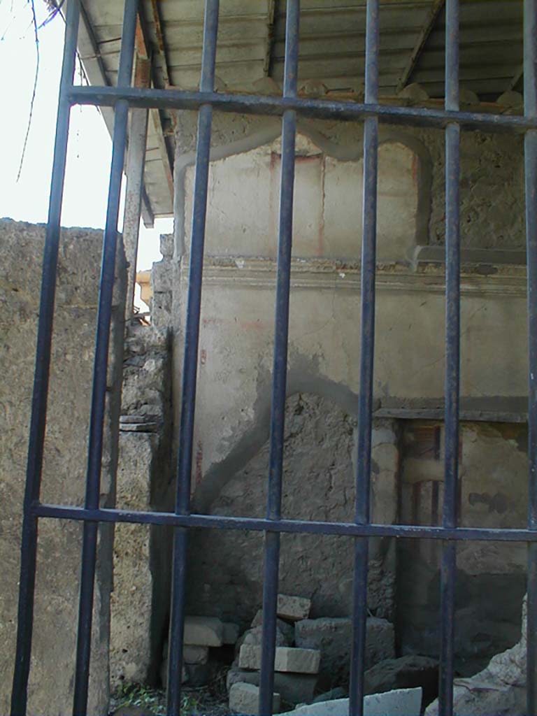 VII.4.62 from VII.4.63, Pompeii. May 2005. 
Looking south into cubiculum towards the remains of the upper south wall, across a site of a staircase to upper floor, through window in shop at VII.4.63.
