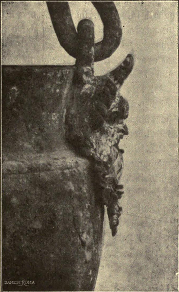 VII.6.38 Pompeii. Nell'ambiente 34, cioè in fondo al corridoio 30: elegantissimo ahenum in lamina di bronzo.
Maniglia ad arco, girante in due anelli opposti, sotto ciascuno dei quali è una maschera in bronzo di divinità aquatica maschile, magistralmente modellata.
See Notizie degli Scavi di Antichità, 1910, p. 455, fig. 6.
