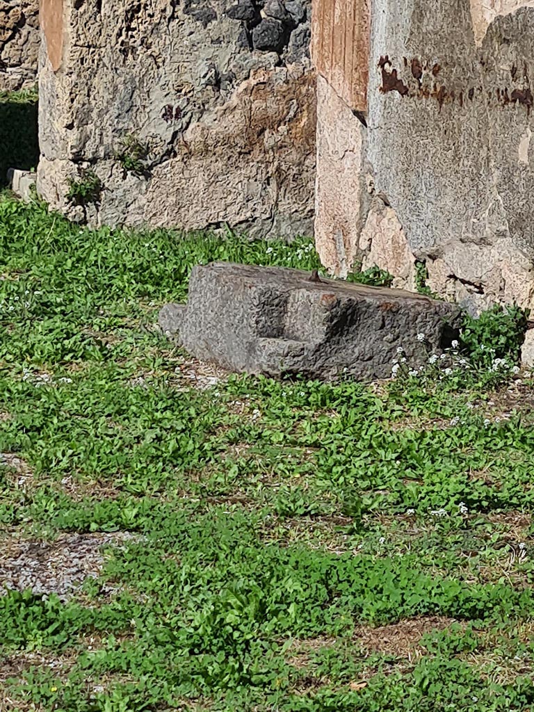 VII.7.10 Pompeii. October 2024. 
Lava-stone base on east side of atrium for holding money/strong box. Photo courtesy of Klaus Heese.
