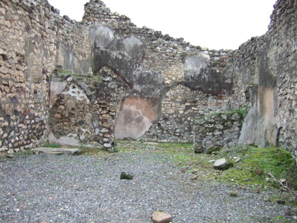 VII.10.6 Pompeii. December 2005. Looking east across shop towards doorway to rear room.
In the north-east corner of the shop-room (on left) can be seen the remains of the base of steps to upper floor.
According to Amoroso, the floor of the shop was simple cocciopesto, whereas the rear rooms floor was the same flooring made with scattered polychrome pieces, similar to the adjacent atrium (of VII.10.5), of which this room had once been part. The walls of the two rooms were plastered with plaster without colour.
Studi della Soprintendenza archeologica di Pompei, 22: lInsula VII, 10 di Pompei , by Angelo Amoroso. (p.69)

