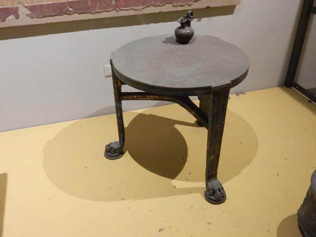 VII.16.17-22 Pompeii. May 2018. Table in bronze with lion’s paws. Parco Archeologico di Pompei, inventory number 13108. 
Pitcher (jug) in bronze with the face of a follower of Dionysus at the base of the handle. Parco Archeologico di Pompei, inventory number 14072.
Photo courtesy of Buzz Ferebee.
