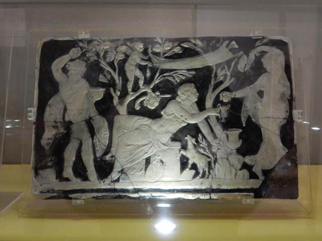 VII.16.17-22, Pompeii. May 2018. Found in the area outside the House of Fabius Rufus.
Cameo-glass panel, this panel possibly alluding to Ariadne’s initiation; a Maenad is pouring wine into her cup in the presence of a dancing Satyr.
Archaeological Park of Pompeii, inv. nos. 153651. Photo courtesy of Buzz Ferebee.

