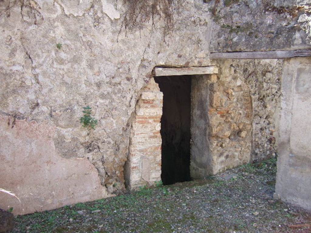 VIII.6.9 Pompeii. September 2005. Looking south-west towards doorway to basement room/water tank under VIII.6.10.  The wall on the right, described by Mau as a thin wall, would have supported the dividing wall between rooms “r” and “s” on the ground floor level. 
See BdI, 1884, p.186, and plan below.

