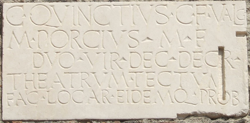 VIII.7.21 Pompeii. September 2005. Second dedication plaque on wall by the entrance from the large theatre.
C QVINCTIVS C F VALG
M PORCIVS M F
DVO VIR DEC DECR
THEATRVM TECTVM
FAC LOC AR EIDEMQ PROB    [CIL X 844b]
 
C(aius) Quinctius C(ai) f(ilius) Valg(us) 
M(arcus) Porcius M(arci) f(ilius)
duovir(i) dec(urionum) decr(eto)
theatrum tectum 
fac(iundum) locar(unt) eidemq(ue) prob(arunt)    [CIL X 844b]
 
Gaius Quinctius Valgus, son of Gaius, and Marcus Porcius, son of Marcus, duumvirs, by decree of the town councillors awarded the contract for the construction of the covered theatre and also approved it.
See Cooley, A. and M.G.L., 2004. Pompeii: A Sourcebook. London: Routledge. (p.20, B9). CIL X 844=ILS 5636.
 
A Theatrum Tectum was a covered theatre; in this case it refers to the Small Theatre or Odeon in Pompeii.
