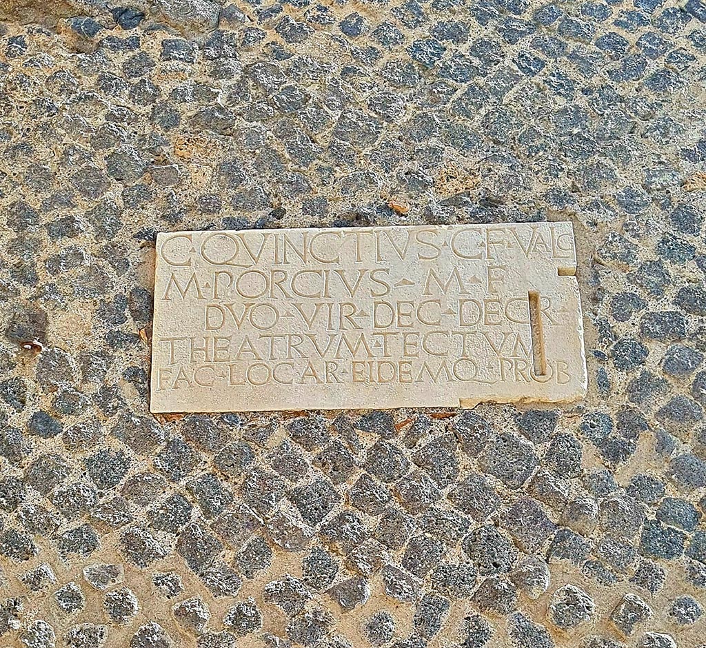 VIII.7.21 Pompeii. Pompeii. September 2024. 
Dedication plaque on wall by the entrance from the large theatre to the small theatre. Photo courtesy of Giuseppe Ciaramella.
