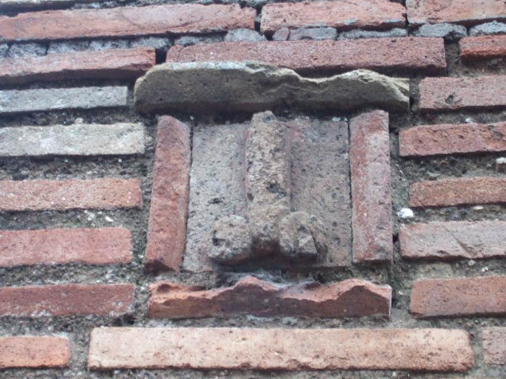 Plaque between IX.1.13 and IX.1.14.  December 2005. According to Gallo, the sign on the faade showing a tufa phallus was the only merit of this shop.
The plaque, originally painted azure blue, shows an erect phallus with appendices painted in red, with an inscription painted in red below:
Ubi me iuvat, asido  (CIL IV, 950)
According to Varone, this translates at When it suits me, I sit on it
(Asido is written instead of assido)
See Varone, A., 2002. Erotica Pompeiana: Love Inscriptions on the Walls of Pompeii, Rome: Lerma di Bretschneider. (p.90) 
See Gallo, A: Linsula I della Regione IX, Settore Occidentale, in Studi della Soprintendenza archeologica di Pompei, no. I, 2001, (p.53)
