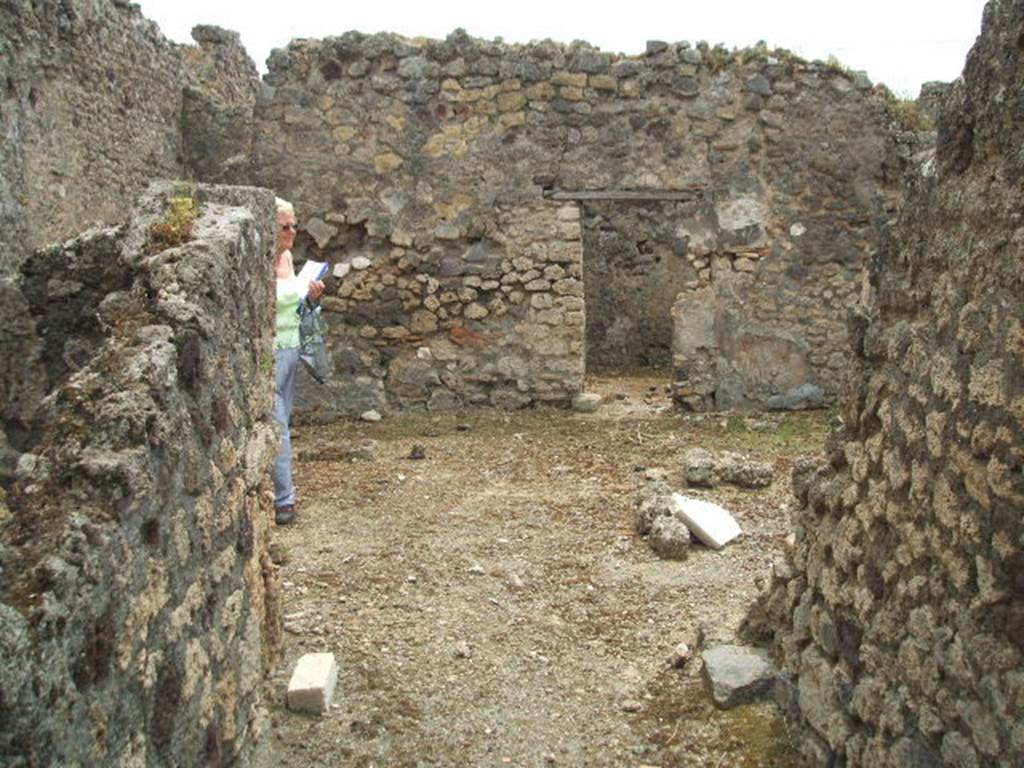 IX.3.23 Pompeii. May 2005. Looking south along entrance corridor to atrium.
According to Fiorelli - “A deserted vicolo, without a pavement existed to the north of the insula, where there were two small houses (IX.3.23 and IX.3.24) on the remains of other ancient dwellings, destroyed perhaps by earthquake.  The first of these houses had a latrine next to the entrance corridor, and at the end of this an atrium, sheltered by two wings of roof, that left a space in the middle entirely uncovered, in which because water did not overflow into the part underneath the roof, a small podium was built.  To the left, perhaps was the kitchen attached to the latrine, and the triclinium was on the right, followed by a room without closure used as the tablinum, then a cubiculum and the garden, near to which was a storeroom containing the cistern. The last door led into the dormitory with capacity for a few beds.” 
See Pappalardo, U., 2001. La Descrizione di Pompei per Giuseppe Fiorelli (1875). Napoli: Massa Editore. (p.147).
See Fiorelli, G, (1875). Descrizione di Pompei, (p.399)
