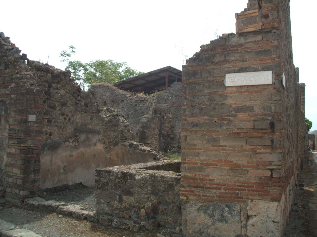 IX.7.22 Pompeii. May 2005. Looking south to entrance, from crossroads with Vicolo di Tesmo. According to Della Corte, the name of the host could be established from the recommendation written to the right of the entrance:
Tertius rogat  [CIL IV 3831]
See Della Corte, M., 1965.  Case ed Abitanti di Pompei. Napoli: Fausto Fiorentino. (p.197)
According to Epigraphik-Datenbank Clauss/Slaby (See www.manfredclauss.de), this read 
Vibium  Severum
IIvir(um)  i(ure)  d(icundo)  o(ro)  v(os)  f(aciatis)  Tertius  rogat    [CIL IV 3831]
