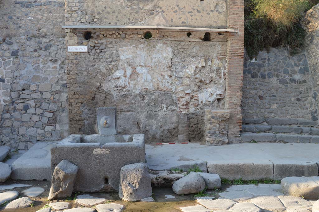 IX.11.1 Pompeii. October 2017. Looking north on Via dellAbbondanza towards fountain with street shrine and altar, at the rear.
Foto Taylor Lauritsen, ERC Grant 681269 DCOR.
