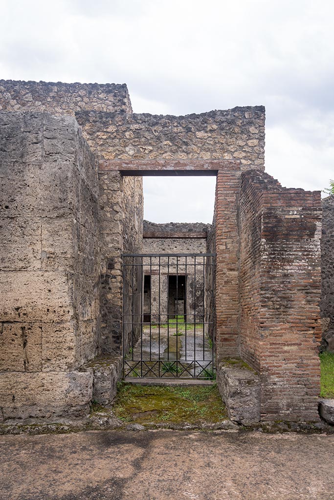 IX.14.2 Pompeii. July 2024. 
Entrance doorway on south side of Via di Nola. Photo courtesy of Johannes Eber.
